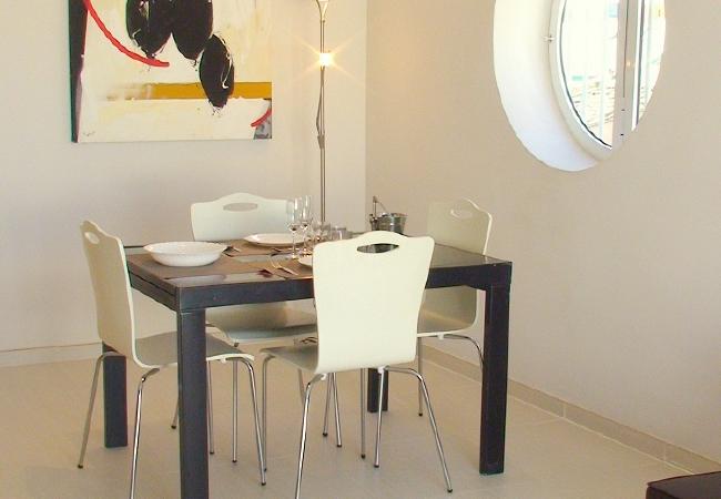 El salón-comedor amplio El salón-comedor cuenta con un sofá, una televisión y una mesa de comedor con sillas.