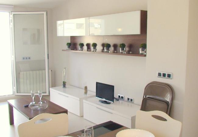 El salón-comedor amplio El salón-comedor cuenta con un sofá, una televisión y una mesa de comedor con sillas.