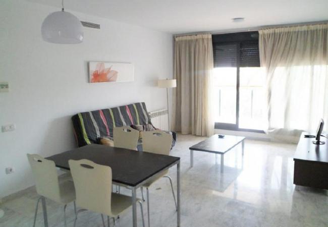 El salón-comedor amplio El salón-comedor amplio cuenta con un sofá, una televisión y una mesa de comedor con sillas.
