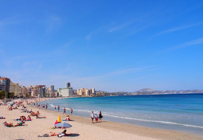La playa de arena de Calpe Calpe tiene una playa de arena maravillosa con muchos restaurantes y tiendas cercas.
