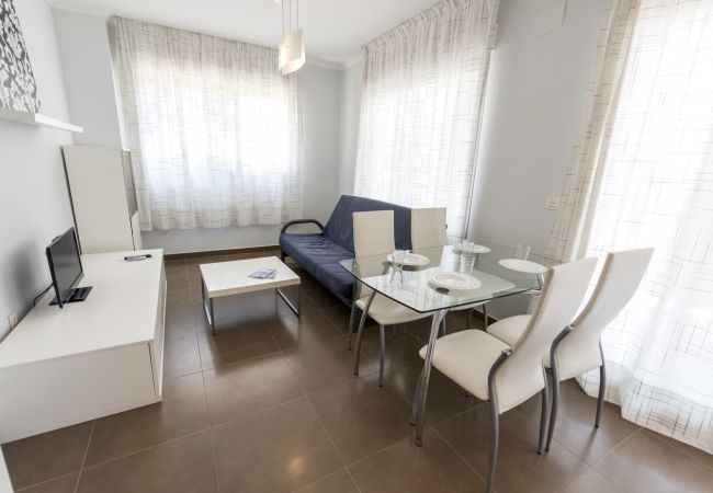 El salón-comedor amplio El salón-comedor amplio tiene una mesa de comedor con sillas, un sofá, una televisión y más muebles.