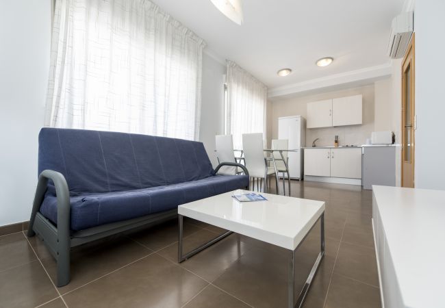 El salón-comedor amplio El salón-comedor amplio tiene una mesa de comedor con sillas, un sofá, una televisión y más muebles.