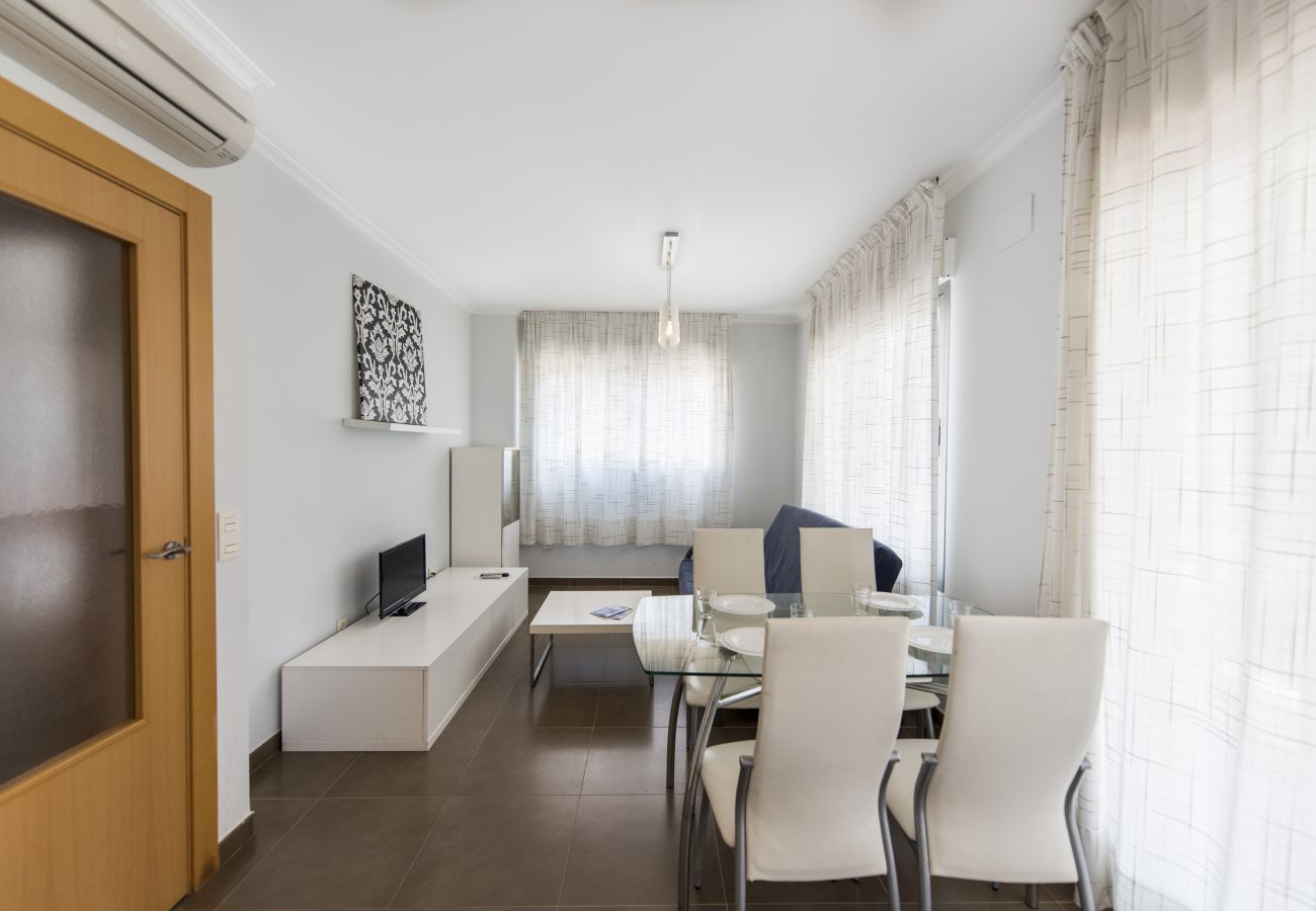 El salón-comedor amplio El salón-comedor amplio tiene una mesa de comedor con sillas, un sofá, una televisión y más muebles.