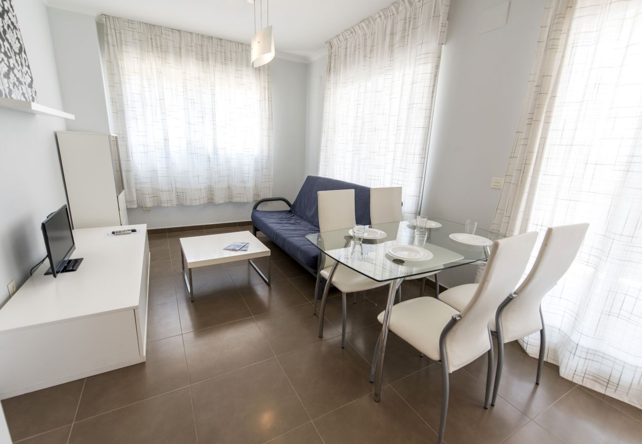 El salón-comedor amplio El salón-comedor amplio tiene una mesa de comedor con sillas, un sofá, una televisión y más muebles.
